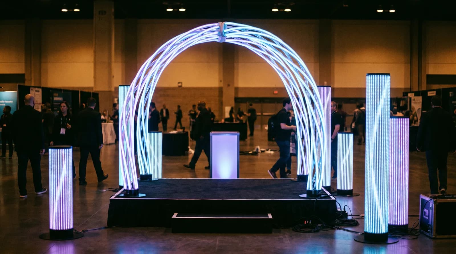 Freestanding LED columns and an arch framing a product-launch stage